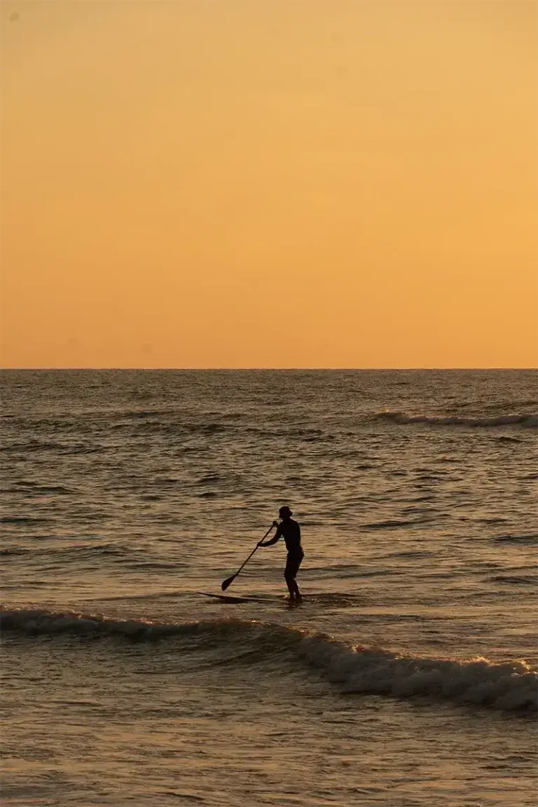A surfer at sunset on Bat Galim beach, three minutes from the hotel